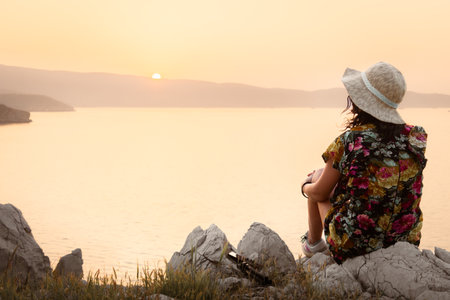 Tourist woman sit enjoy sunset panorama on viewpoint in persian gulf islandの写真素材
