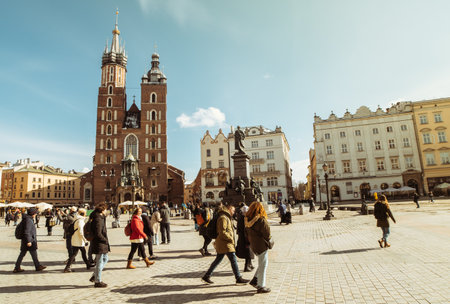 Krakow, Poland - 6th march, 2023: guide with tour group walk together in main square in Krakow. Free tourist walking tours with locals. St.Mary Basilica. XIII century Krakow squareのeditorial素材