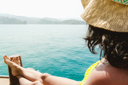 Woman tourist on holiday enjoying boat tour lay on deck smile with persian gulf sea background.の写真素材