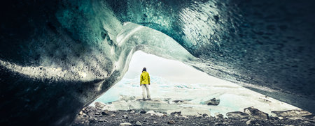Panoramic view of tourist by FjallsjÃ¶kull glacier in Iceland from inside glacier cave. Explore sightseeing Iceland hidden gems. Famous travel destination south Icelandの写真素材