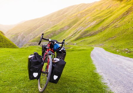 Close up touring bicycle stand in green mountains summer nature. Cinematic summer countryside cycling template. Green travel by bicycle. Bicycle touring holiday outdoors adventureの写真素材