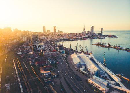 Batumi, Georgia - 25th november, 2021: transportation in Batumi Railway view with port panorama and waterfront promenade with sunset over horizon and skyscrapersの写真素材