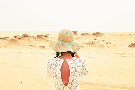 Female tourist visit sit on bench take photo of Fossil Dunes Structures. Abu Dhabi, UAE. Famous travel destination outside capitslの写真素材