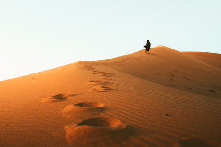 Low angle view beautiful woman in long dress barefoot follow walk on KAshan desert dunesの写真素材