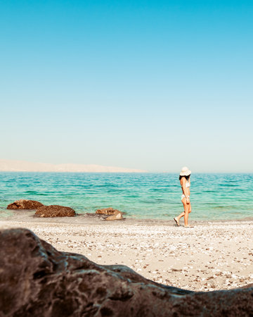 Panorama attractive caucasian tourist woman in white bikini walk on white sand beach alone explore...