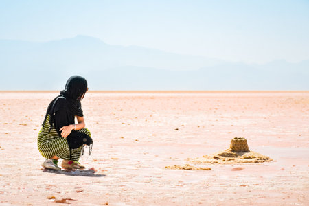 Female traveler tourist sit visiting explore Maharlu pink salt lake shore. Travel destination Iran in Shirazの写真素材