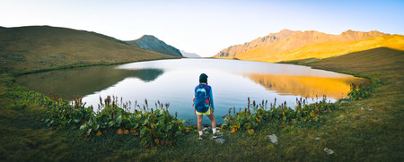 Female caucasian woman hiker stand enjoy peaceful lake panorama in Lgodekhi national park, Georgia...