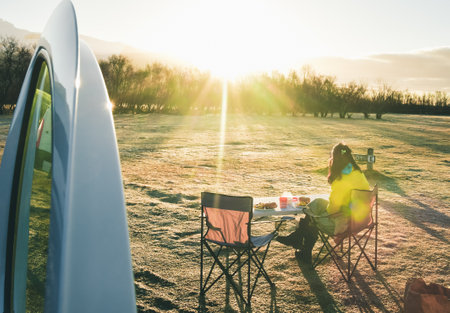 Tourist sit eat breakfast in sunny morning by camper van in official Icelandic campsite while travel on vacation with camper van. Skaftafell campground by glacier in national parkの写真素材
