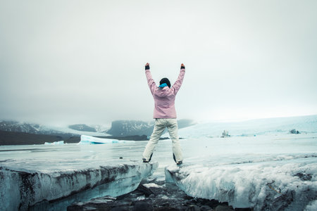 Tourist woman visitor stand by beautiful Fjallsjokull glacier on ice in Iceland. Inspirational travel explore holidays Iceland conceptの写真素材