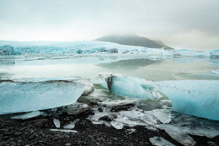 View of a blue iceberg broken off from the glacier tongue of FjallsjÃ¶kull in the glacier lagoon...