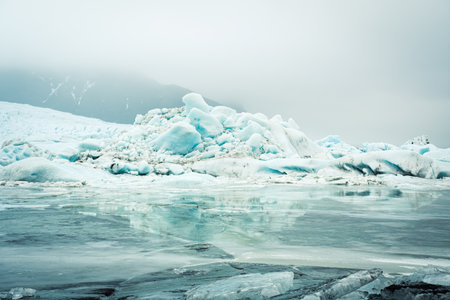 Close up Fjallsjokull glacier icebergs in overcast rainy day in Iceland with water drops. The...