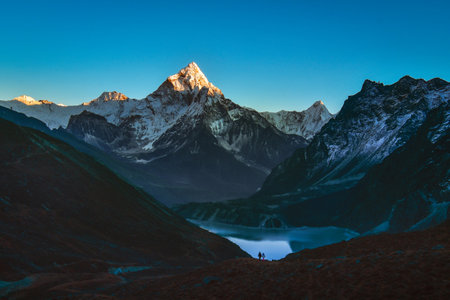 Ama dablam mountain peak and Cholatse lake. Sagarmatha national park. Ama Dablam - mountain in the eastern Himalayan range of Koshi Province, Nepal. Main peak.Man and woman trekkerの写真素材