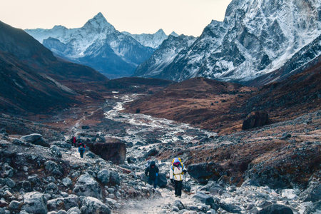 Group of trekkers trekking in Himalayas mountains through Cho la glacier and pass. to Gokyo Ri. Nepalese male guide leading tourist client in Sagarmatha national park official trekの写真素材