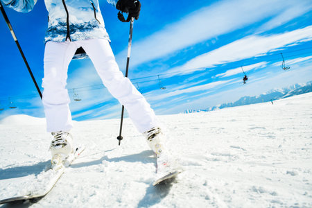 Unrecognizable woman waist down pose with ski outfit with mountains background. Ski holiday capture social media promo copy space backgroundの写真素材