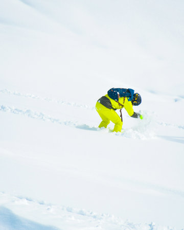 Close up snowboarders gets stuck on free-ride downhill in ski resort on fresh powder day winter outdoorsの写真素材