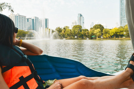 Young caucasian woman enjoying sunny day on paddle boat Visit public Lumpini Park most popular park...