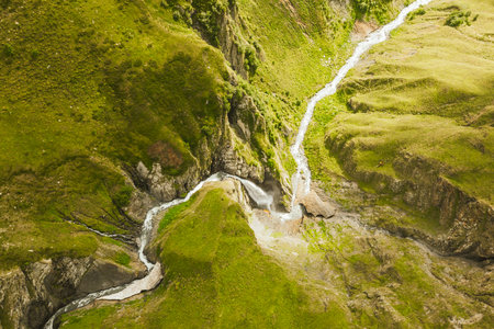 Aerial zoom in view Chkatiskari waterfall on Nariana lake trail in Gudamakari. Caucasus mountains in...