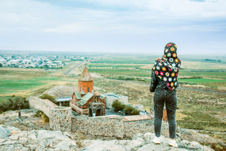 Happy tourist blogger arms up by famous Khor Virap monastery.Khor Virap is an Armenian monastery located in the Ararat Plain in Armenia. Ararat Province, within the territory of ancient Artaxataの写真素材