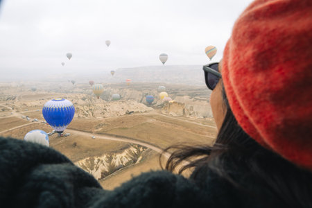 close up view hot air balloon passengers woman enjoy Cappadocia balloons take-off views inside hot air balloon basket in winter. Cappadocia hot air balloon flight attraction conceptの写真素材