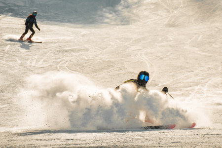 Expert skier on the slope in Winter snowy mountains sunny day outdoors carve spray snow. Skills and professional skiing instructor. Mestia ski resort holidays in Svaneti mountain region Georgiaの写真素材