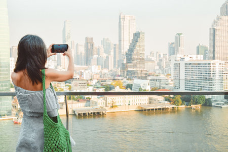 Bangkok, Thailand - 11th february, 2024: woman tourist stand photograph on Iconsiam shopping mall famous viewpoint over river in sunny hot day in southeast asia popular destination Bangkok, Thailandの写真素材