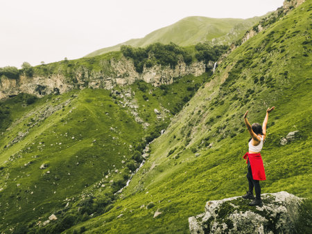 Aerial view happy woman hiker standing on the top of mountain ridge against mountains.Georgia travel sightseeing outdoors caucasus mountains.Sport and healthy lifestyle conceptの写真素材