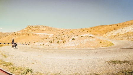 Fit young caucasian male cyclist push bicycle uphill with mountains background outdoors in caucasus mountains. Achievement , inspiration, challenge and determination conceptの写真素材