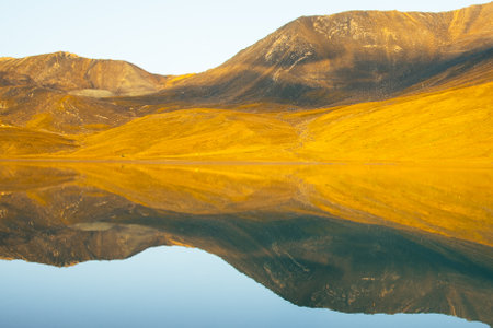 Beautiful lake and tents by shore early morning on sunrise before hike. Hiking destination and...
