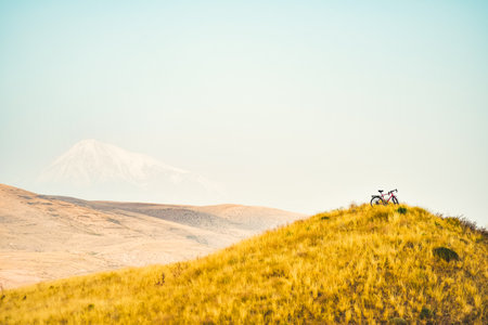 Touring bicycle uphill stand on mountain viewpoint. Off-road cycling outdoors in mountains extreme challenging conditions. Love bicycle and addictionの写真素材