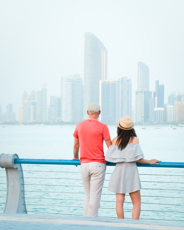 Caucasian tourist romantic couple stand together enjoy skyline panorama on scenic viewpoint in Abu dhabi. Visit travel sightseeing UAE conceptの写真素材
