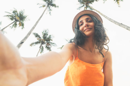 Natural caucasian woman in 40s pose selfie smile to camera on vacation in tropical island surrounded...