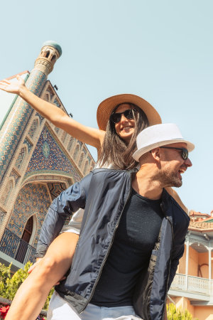Carefree couple walk in city express affection freedom. Woman and man piggyback both laughing and...