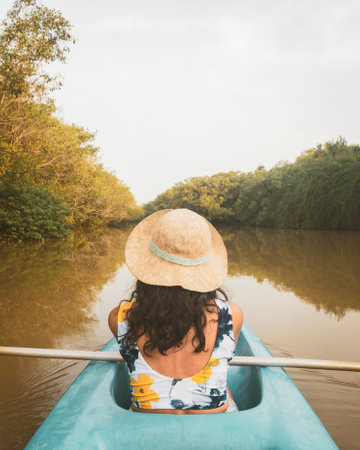 Woman sit in kayak POV row in mangrove on sunrise do active sports outdoors enjoy holidays relax having fun on travel destination Sri lanka, Tangalle, south coast.の写真素材