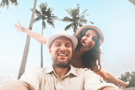 Happy couple of travelers taking selfie pic in tropical island - Two cheerful tourists visiting asia...