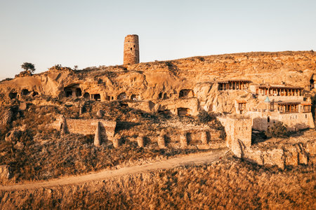 Aerial view of an ancient Orthodox monastery carved into remote cliffs amid vast hills, symbolizing solitude, isolation, and spiritual retreat in Georgiaの写真素材