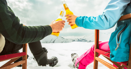 Couple relax sit on chairs in snowy ski resort with beer bottle, concept of leisure, winter holiday, relaxation, carefree lifestyle, freedom, cozy outdoor relaxation momentの写真素材