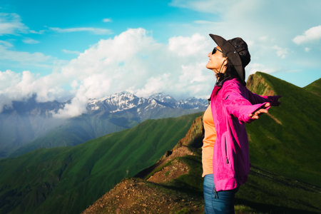 Young fit hiker girl breathing fresh mountains air outdoors in summer while hike on viewpoint.Woman...