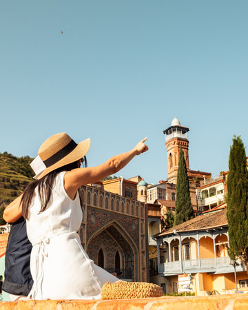 Couple of tourists in street hug enjoy beautiful Tbilisi old city colorful buildings at holidays in...