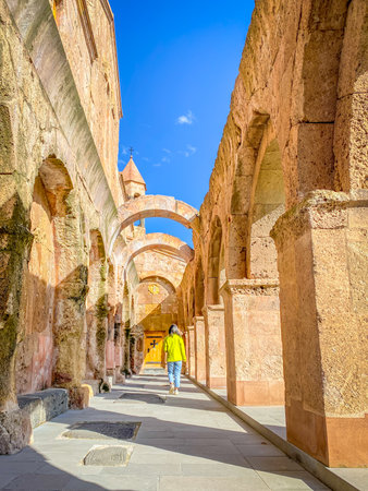 Woman walk visit walk by Arched columns and old brick wall of Odzun Church. Armenian basilica constructed around the 5thâ7th century in the Odzun village of the Lori Province of Armeniaの写真素材