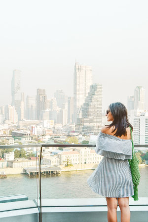 Close up woman tourist stand photograph on shopping mall famous viewpoint over river in sunny hot...