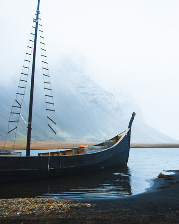 Traditional Viking style wooden longship docked at Viking Village replica near Stokksnes, Iceland....