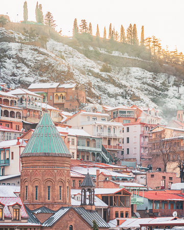 Snow covered rooftops and historic churches of Tbilisi old town in winter with hillside view and Caucasus atmosphereの写真素材