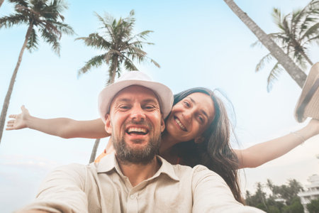 Young happy couple visit coconut island pose happy face taking holiday photo selfie in Sri lanka, Mirissa. People on holiday lifestyle conceptの写真素材
