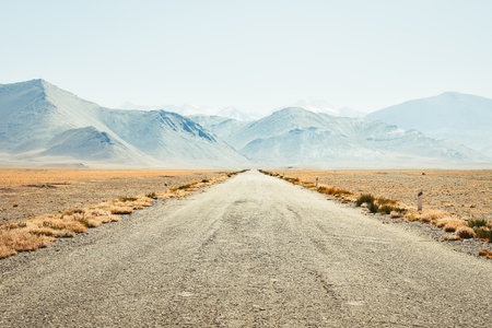 The M41 or Pamir Highway road with Pamir Mountains background. Popular travel expedition and adventurous route among cyclist motorcyclist and 4wdの写真素材
