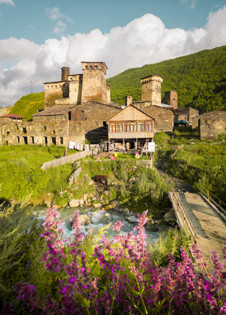 Zhibiani district Ushguli village Svaneti Georgia stone towers wooden house bridge over river...