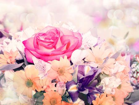A bouquet of flowers with a focus on the rose and iris in a light grunge style.の写真素材