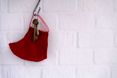 Ð red mask and keys hang on a white wallの写真素材