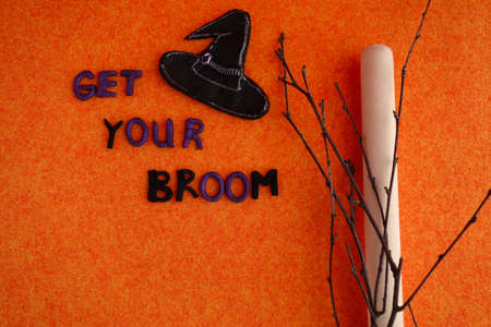 Halloween inscription - get your broom - wooden stick, twigs and witch hatの写真素材