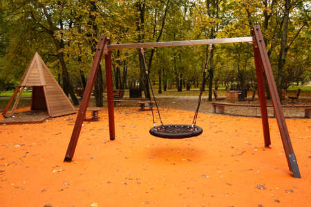 children's park with a nest swing and a wooden wigwam, on an orange backgroundの写真素材