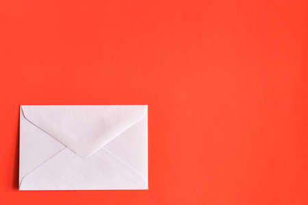 A envelope on a red background with space for text or logo.の写真素材